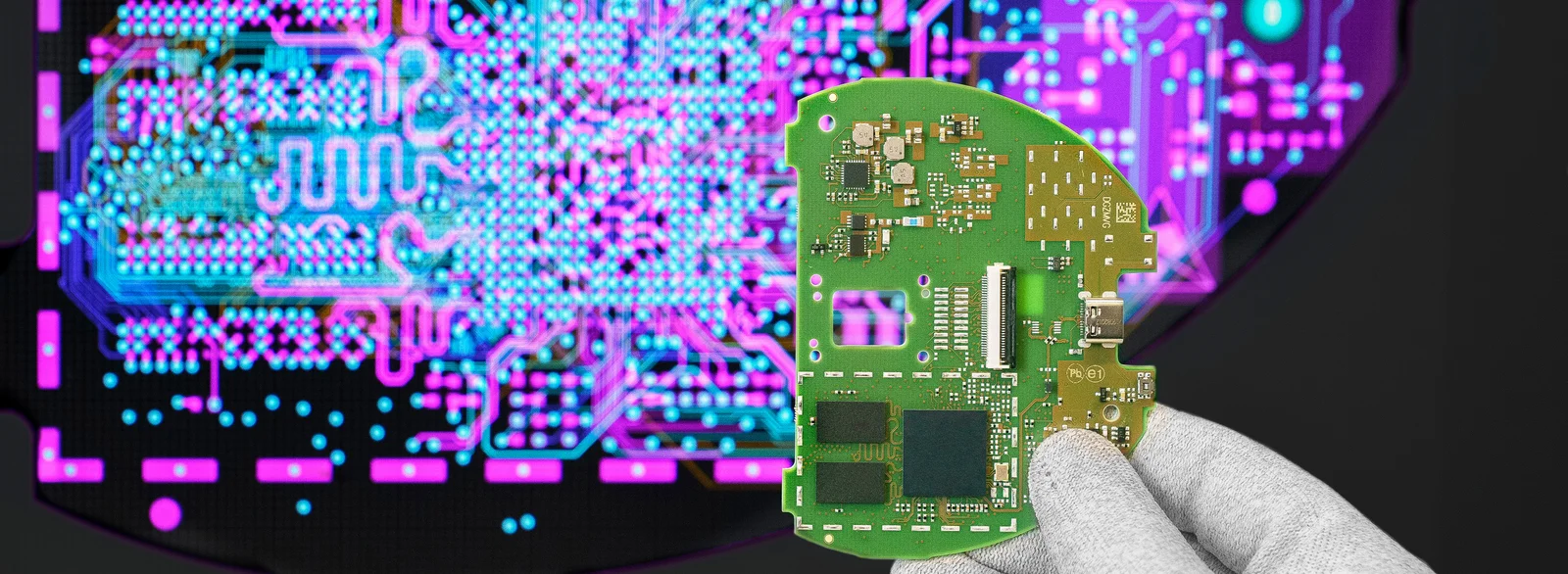 Cicor engineer holding a PCB in front of a screen displaying the PCB design