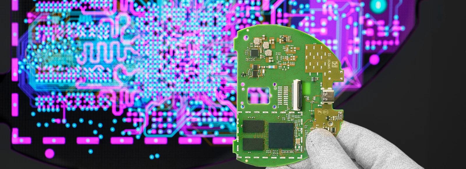 Cicor engineer holding a PCB in front of a screen displaying the PCB design