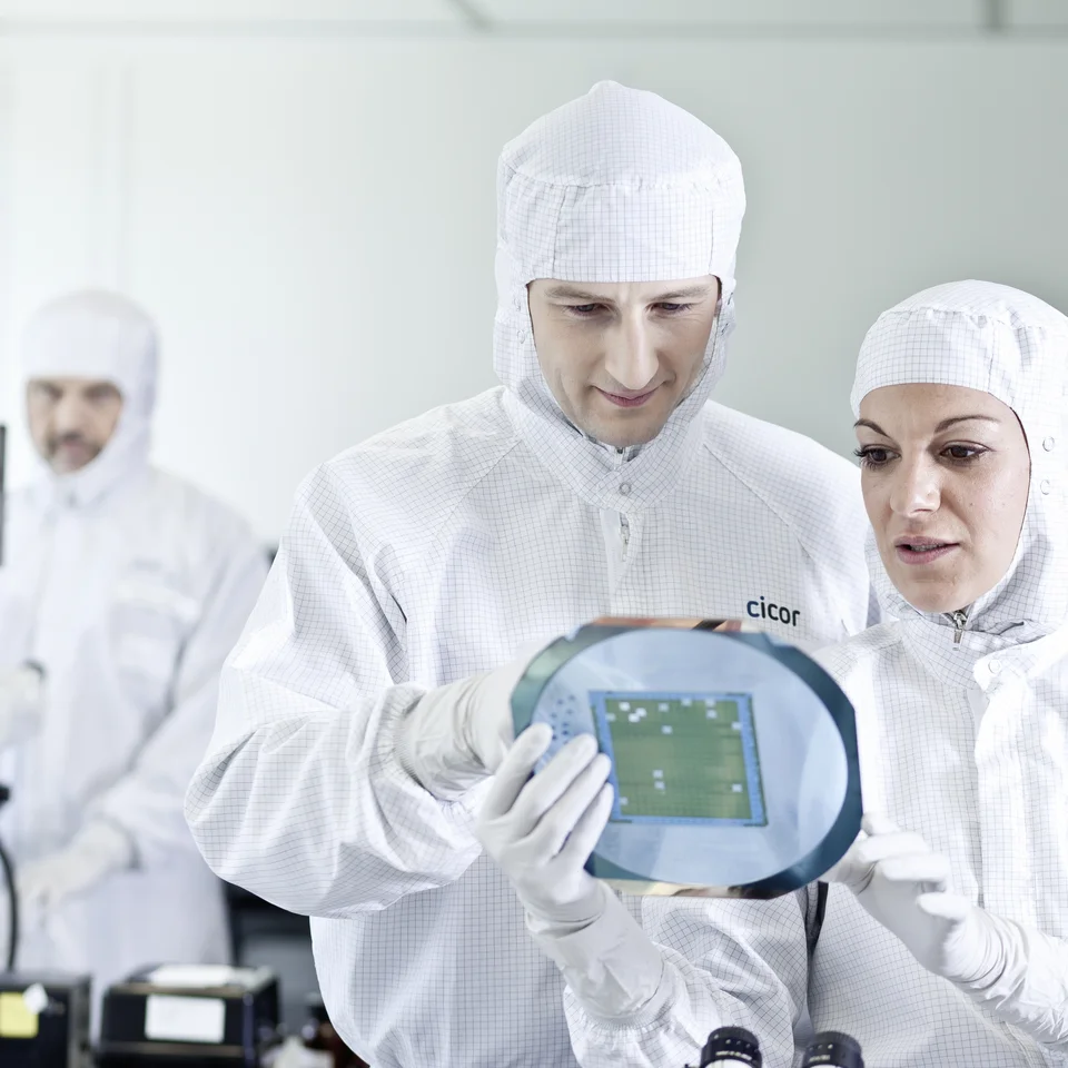 Cicor employees inspecting a thin-film substrate at the Cicor production site in Wangs, Switzerland