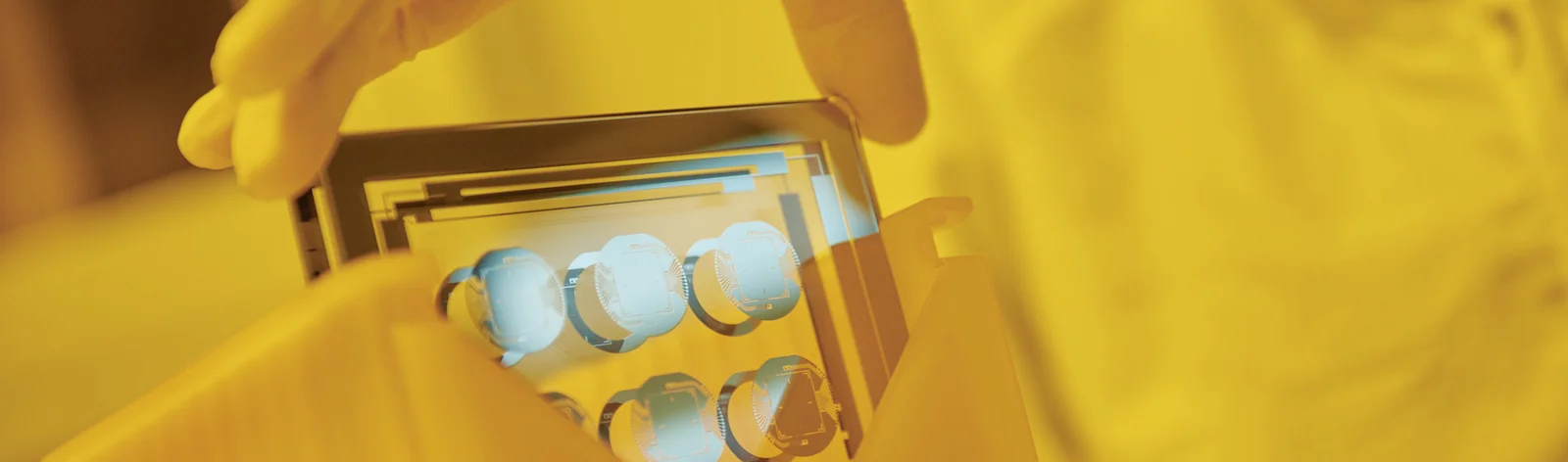 Cicor employee holding a thin-film substate at the production site in Wangs, Switzerland